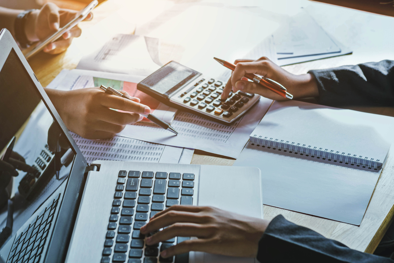 Persona treballant amb documents comptables i calculadora